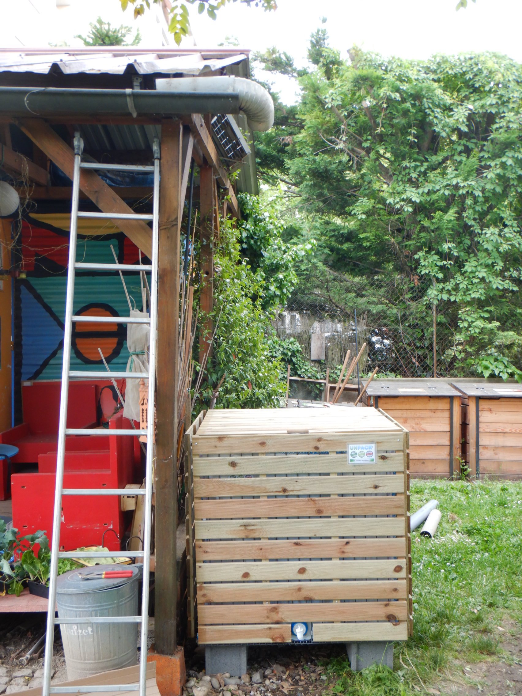 Installation d' une cuve eau de pluie UNPACK sous pluviale dans un jardin partagé à Lyon